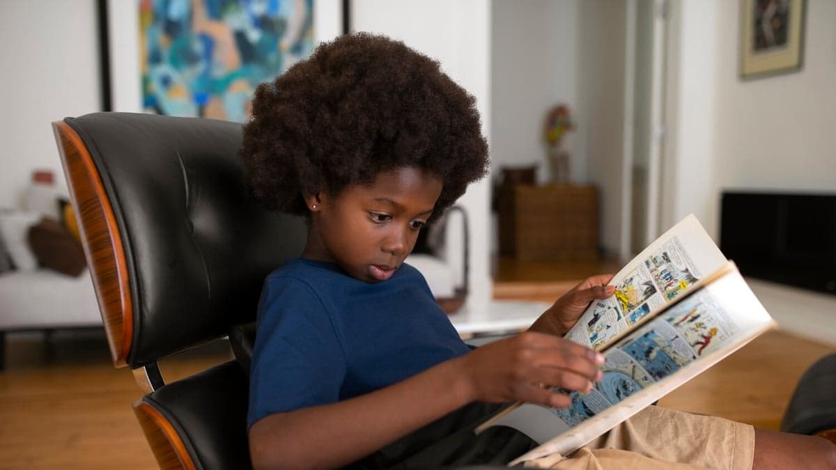 Boy reading a comic in an armchair