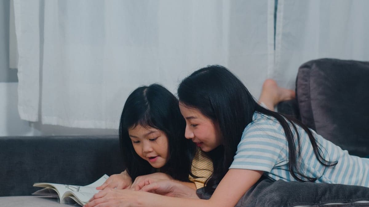 Mother and daughter reading together on a sofa